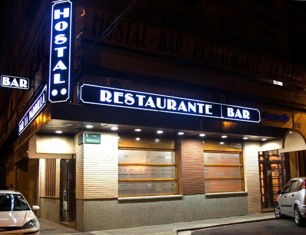 a restaurant with a sign on the side of a building at Hostal la Parrilla in Tudela