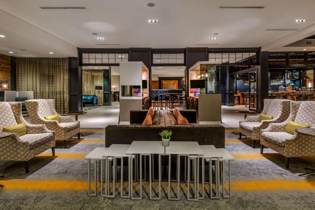 a lobby with couches and tables in a building at Sonesta Charlotte Executive Park in Charlotte