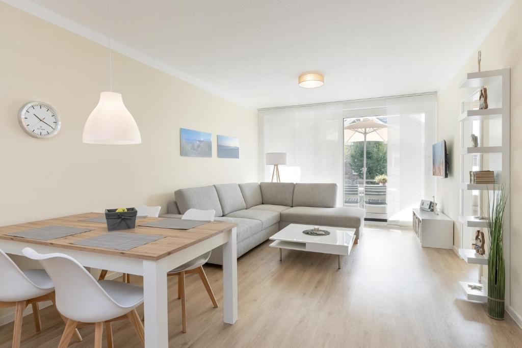uma sala de estar branca com uma mesa e um sofá em Wicheldorfstraße 20 Wohnung 109 em Grömitz
