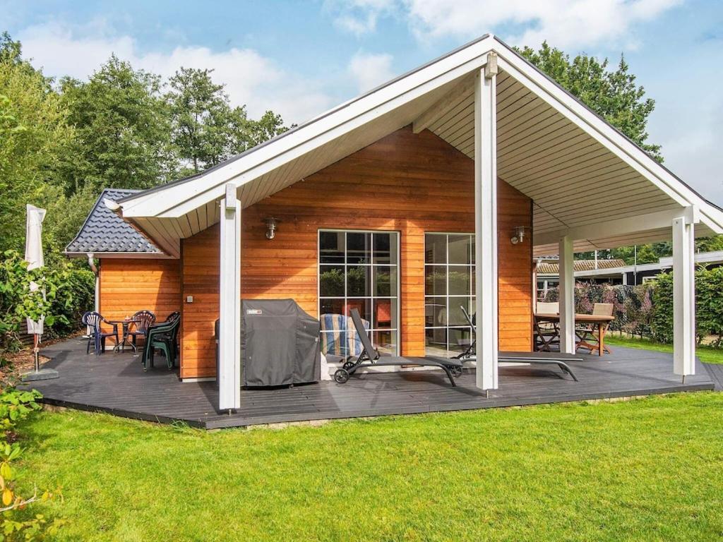 een huis met een houten terras met een dak bij 8 person holiday home in Haderslev in Haderslev