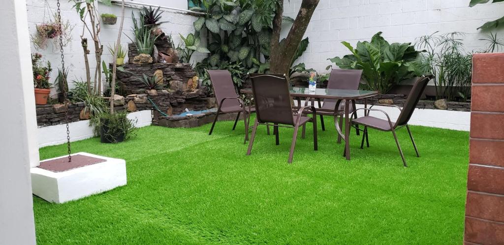 a patio with green grass and a table and chairs at Green life in San Salvador