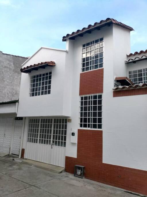 un edificio blanco con muchas ventanas en Hermosa Casa en excelente vecindario en San Gil, en San Gil