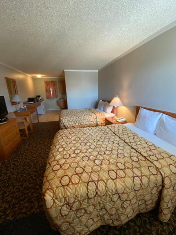 a hotel room with a large bed and a desk at Aspen Motor Inn in Drayton Valley