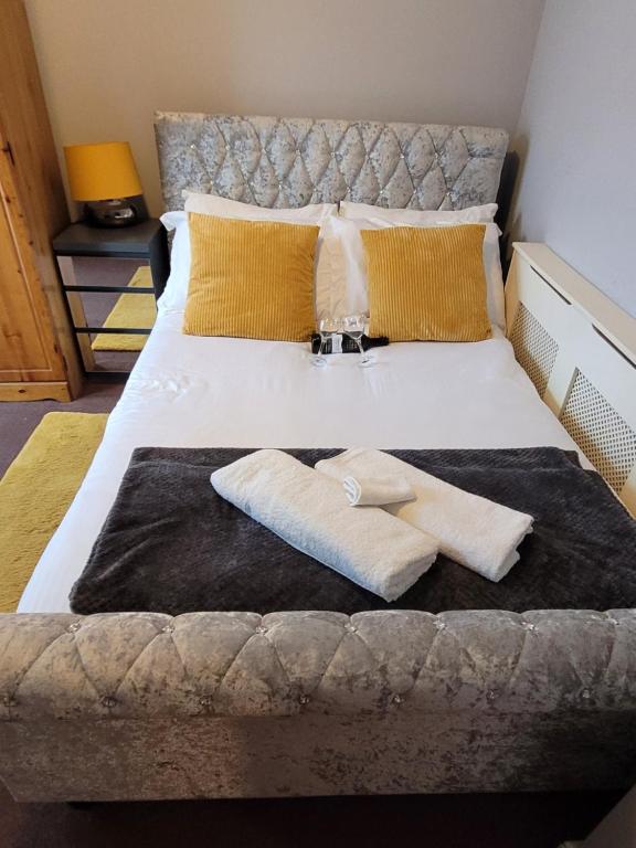 Una cama con dos toallas encima. en Mel's Springfield Home, en Mánchester