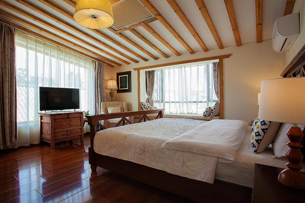 a bedroom with a large bed and a television at Dali Yunxi Boutique Inn in Dali