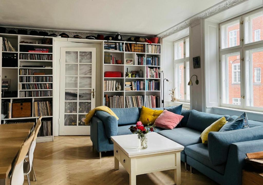 uma sala de estar com sofás azuis e estantes em ApartmentInCopenhagen Apartment 134 em Copenhague