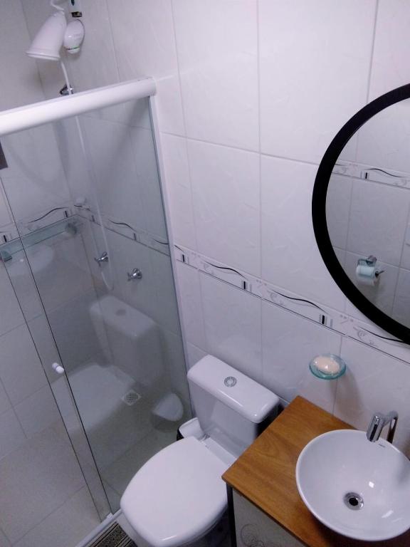a bathroom with a shower and a toilet and a sink at Pousada Casa do Oscar in Governador Celso Ramos