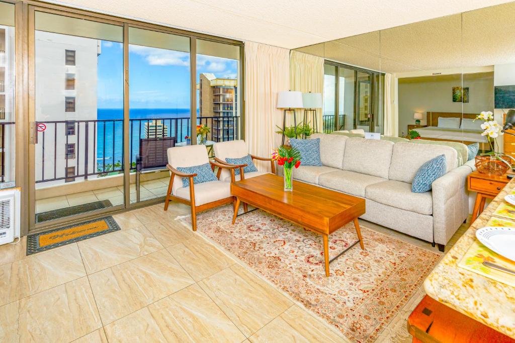 ein Wohnzimmer mit einem Sofa und einem Tisch in der Unterkunft Ocean View Delight, Walk to Beach with Free Parking in Honolulu