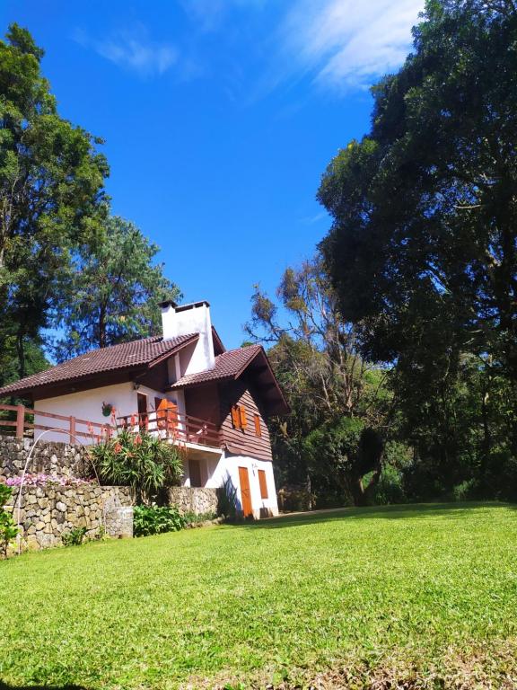 a house with a grassy field in front of it at Refúgio do Selado in Monte Verde