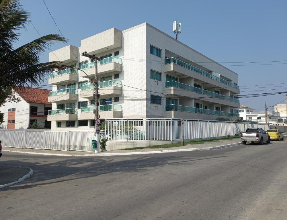 un bâtiment blanc au coin d'une rue dans l'établissement Apto de 2 quartos vista pro mar de Itaúna, à Saquarema
