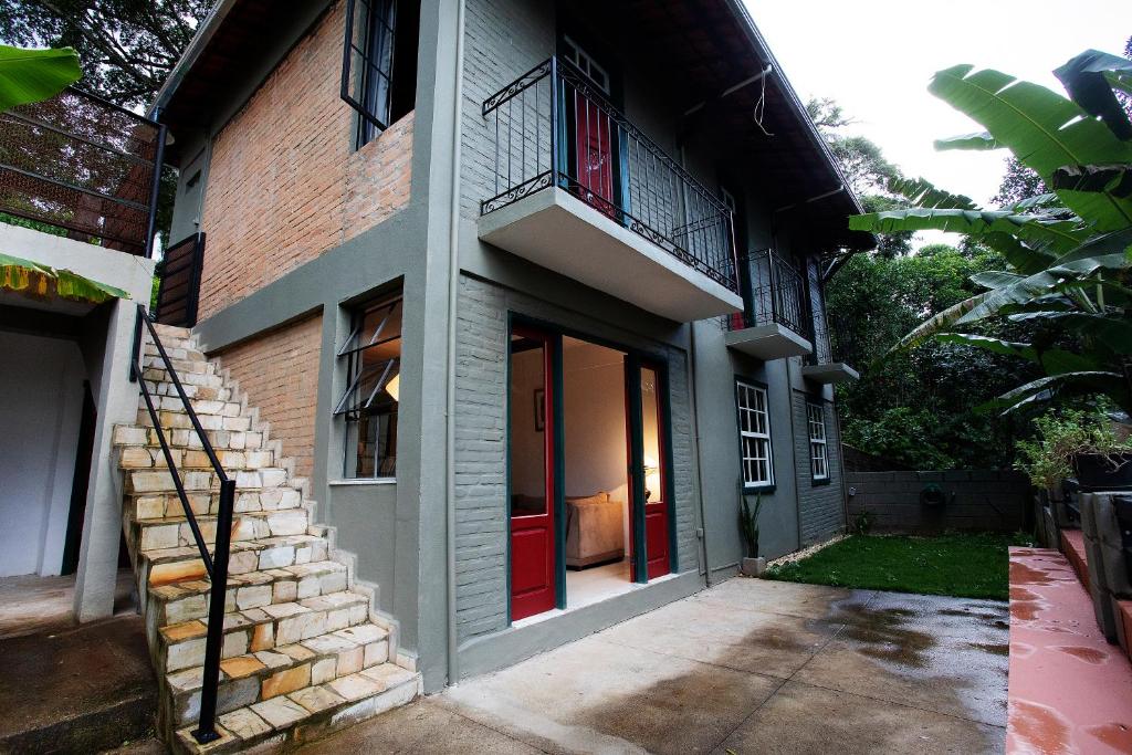 une maison avec une porte rouge et un bâtiment en briques dans l'établissement Casa charmosa e espaçosa, à Tiradentes