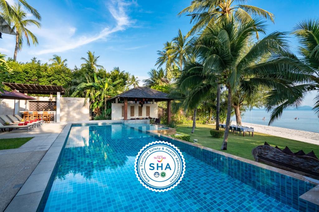 - une piscine en face d'un complexe avec des palmiers dans l'établissement Inasia Beach Villa by Elite Havens, à Lipa Noi