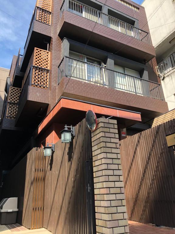 a tall brick building with a balcony on it at Nagomi House in Tokyo