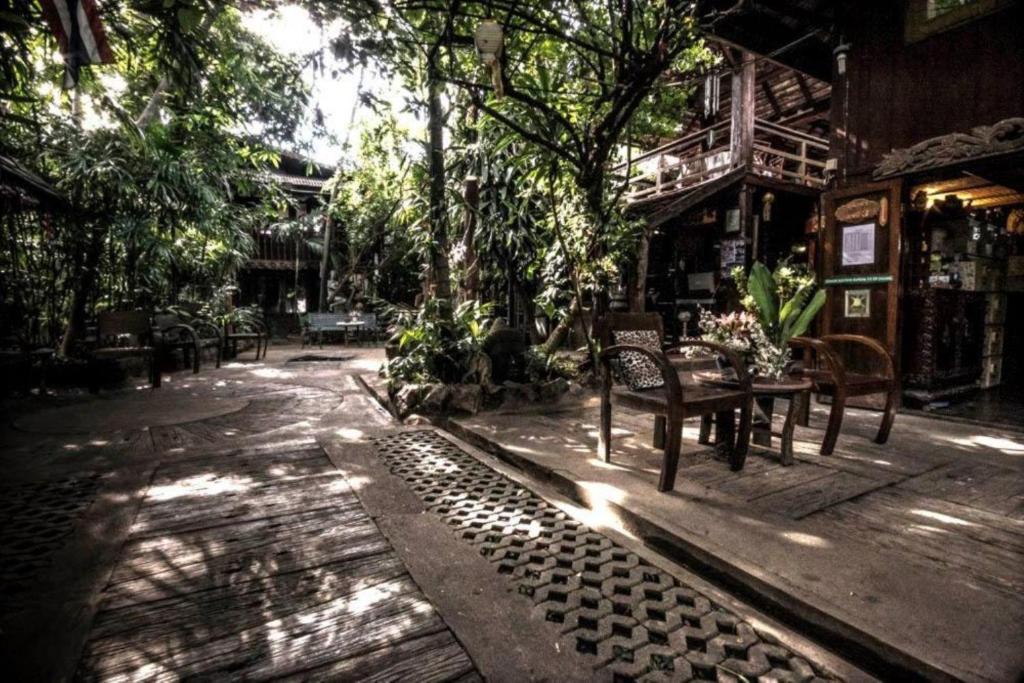 eine Terrasse mit einem Tisch, Stühlen und Bäumen in der Unterkunft Gap's house in Chiang Mai