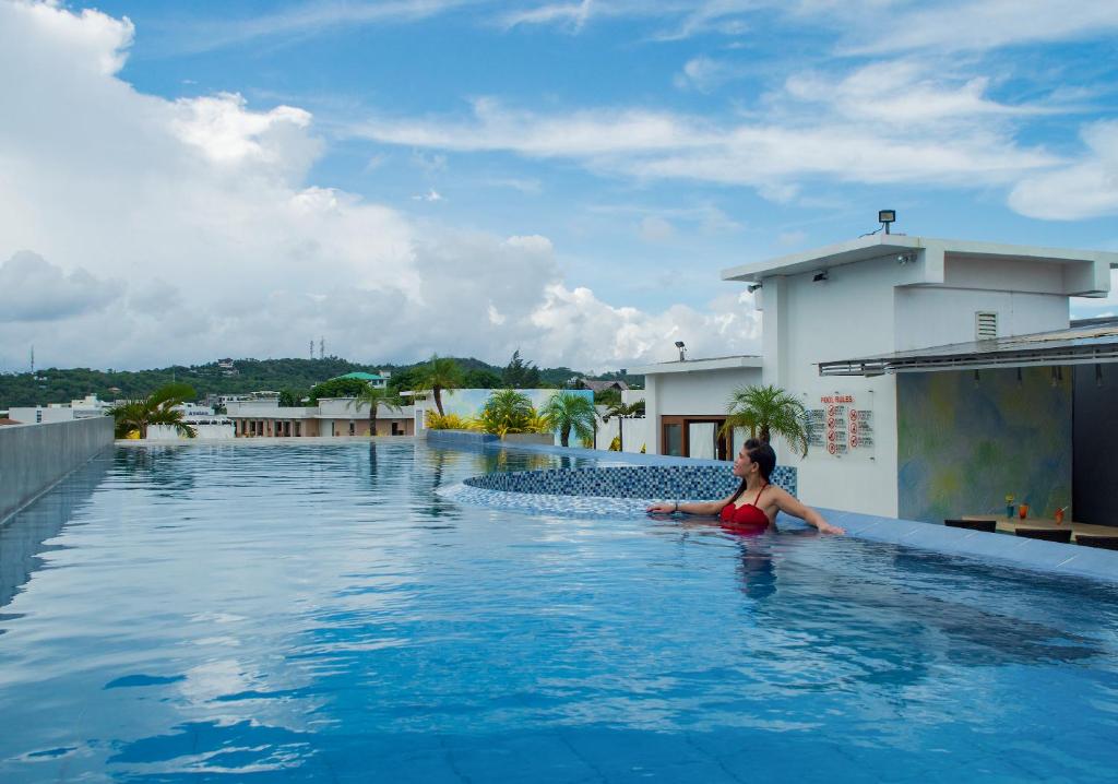 a woman sitting in a swimming pool on top of a building at Aloha Boracay Hotel in Boracay