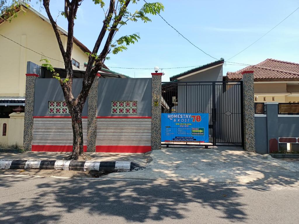 a gate in front of a house with a tree at Homestay dan Kost 78 in Jepara