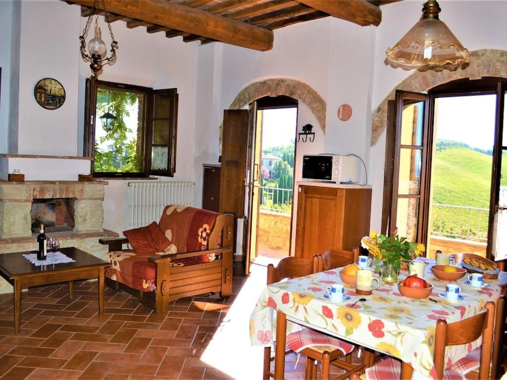 salon ze stołem i kominkiem w obiekcie Holiday Apartment Close to Asciano w mieście Asciano