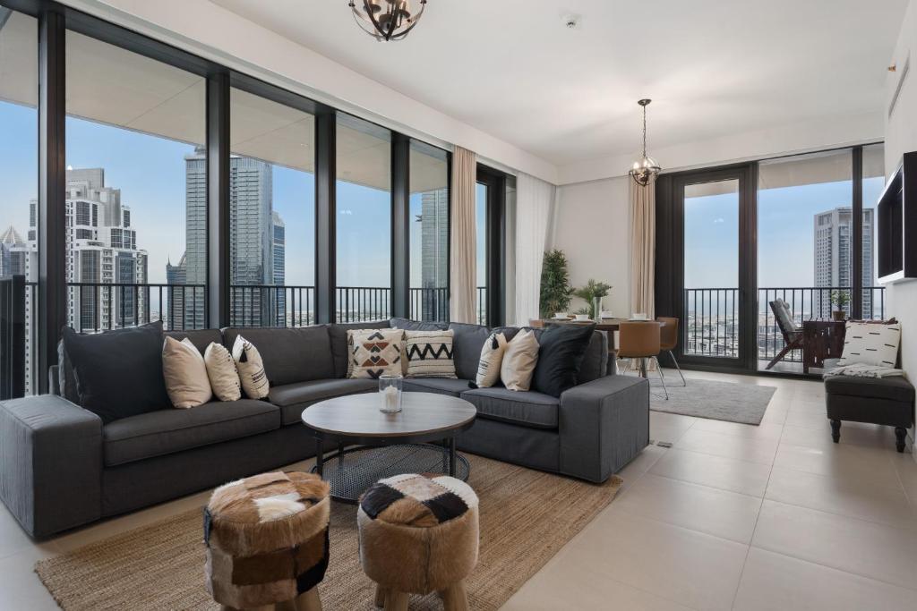 a living room with a couch and large windows at Breathtaking City Views From DT Apt with Terrace in Dubai