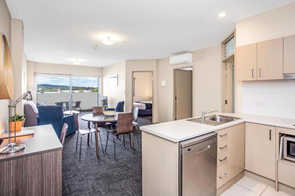 an apartment kitchen and dining room with a table at Hume Serviced Apartments in Adelaide