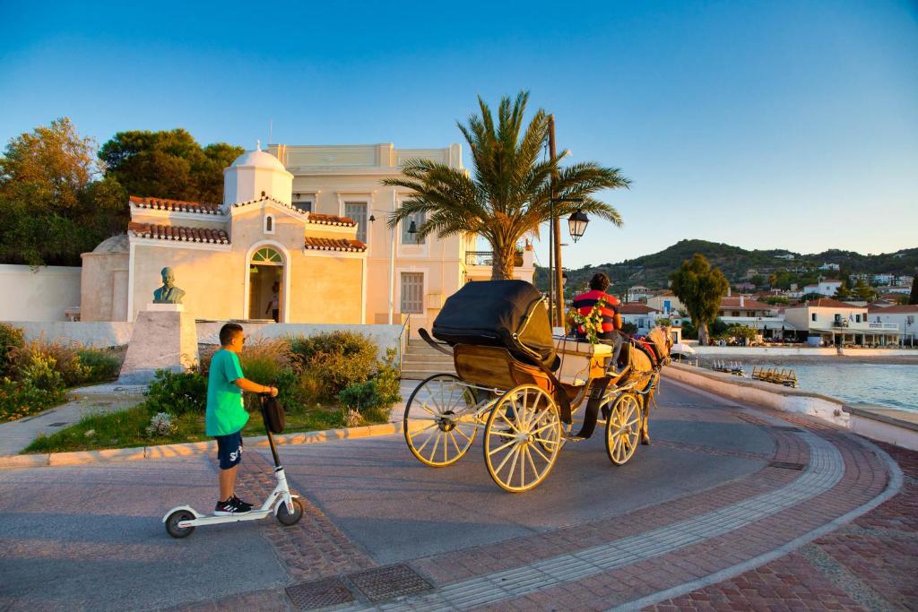 a boy pulling a horse drawn carriage on a street at Argonaftis Spetses in Spetses
