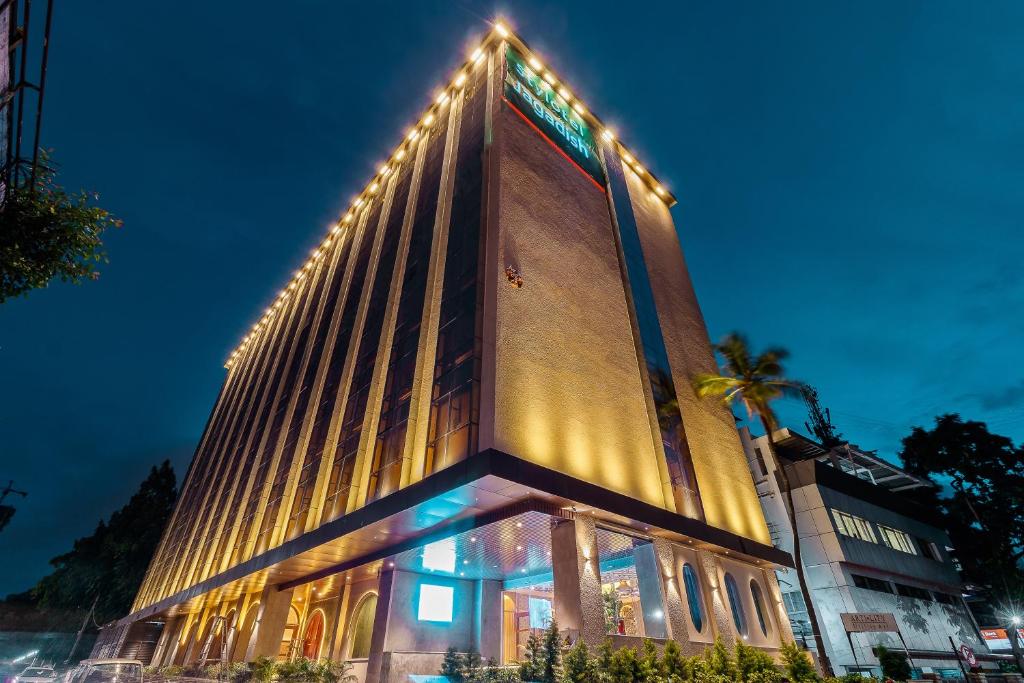 a tall building with lights on the side of it at Jagadish Hotels Sankey Road in Bangalore