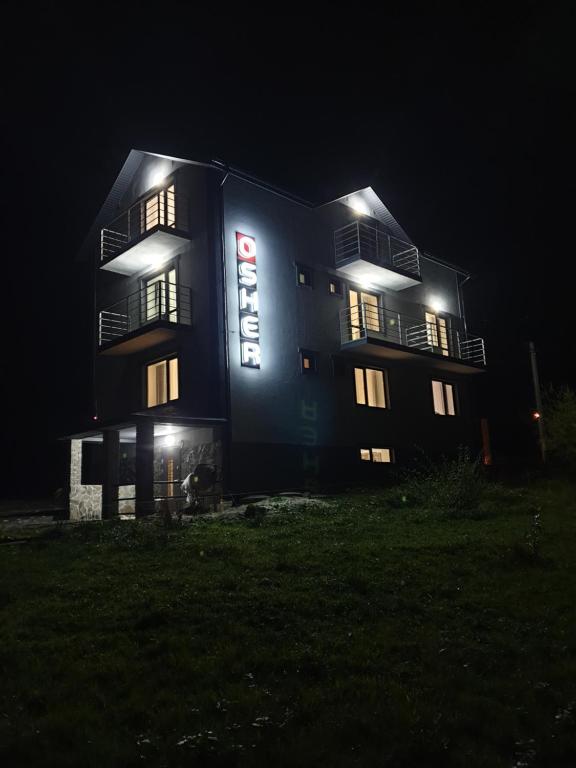 un edificio di notte con le luci accese di Hotel Osher a Bukovel