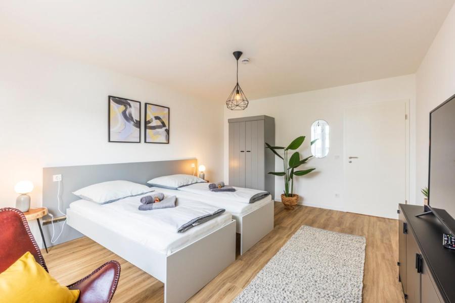 - une chambre avec deux lits et un canapé dans l'établissement Glück Auf Appartements Kaiserstraße Mülheim, à Mülheim
