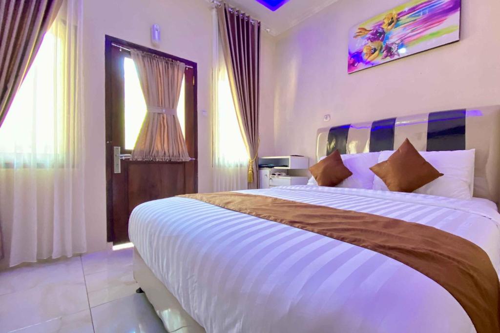 - une chambre avec un grand lit blanc dans l'établissement Homestay Banteng Adventure Dieng Mitra RedDoorz, à Diyeng