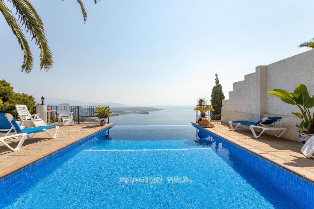 a swimming pool with a view of the ocean at Villa Paraíso Azul in Salobreña