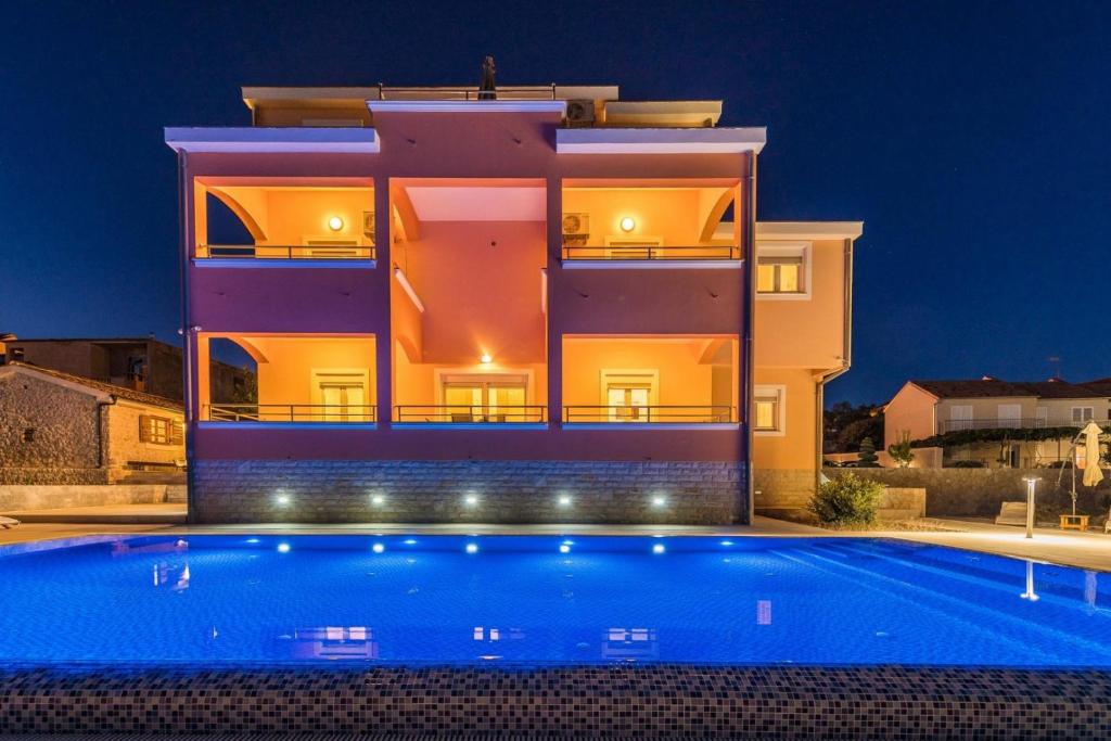 une villa avec une piscine la nuit dans l'établissement Villa Marko, à Sveti Filip i Jakov