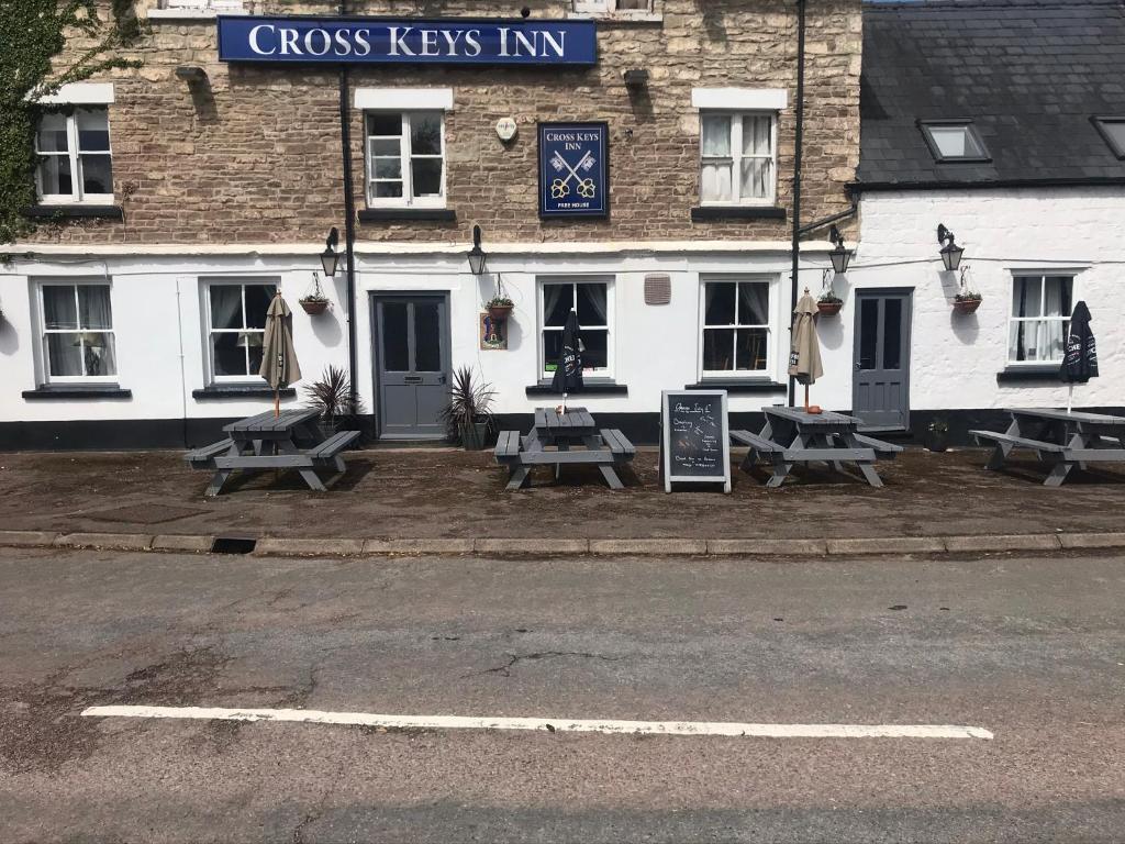 a row of picnic tables in front of a building at Crosskeys Inn Guest Rooms in Wye Valley in Hereford
