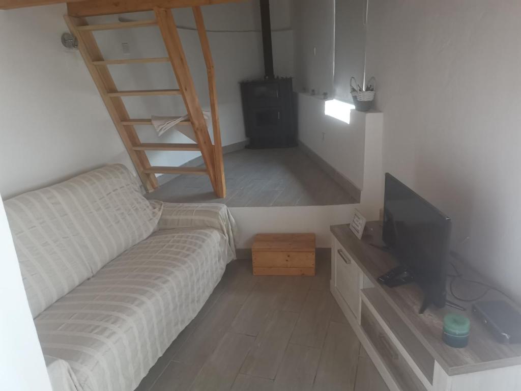 ein Wohnzimmer mit einem Sofa und einem TV in der Unterkunft Casinhas Proença - Family in Aljezur