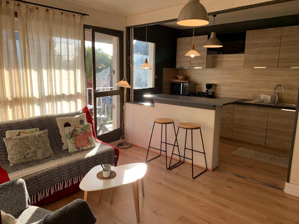 a living room with a couch and a kitchen at Cabourg centre & plage in Cabourg