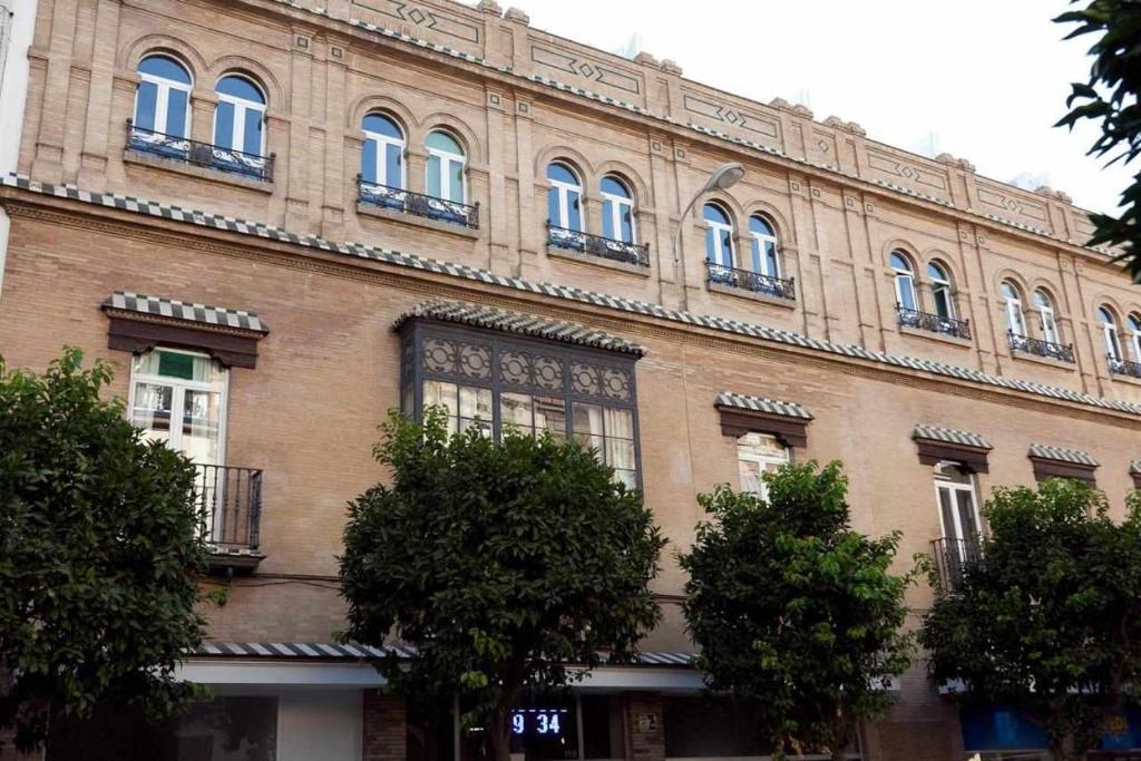 a large brick building with trees in front of it at Lovely Duplex in Seville