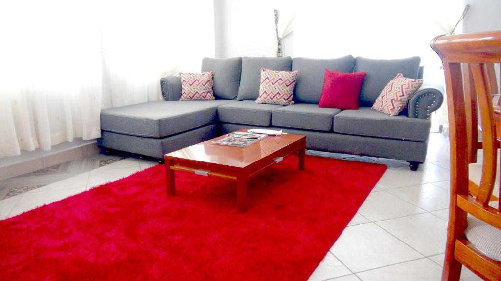 uma sala de estar com um sofá e um tapete vermelho em AVISHAI HOMES em Kisumu