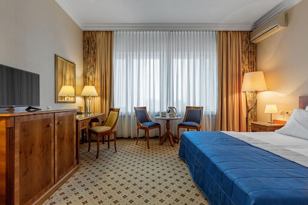 Cette chambre comprend un lit et un bureau. dans l'établissement Natsionalny Hotel, à Kiev