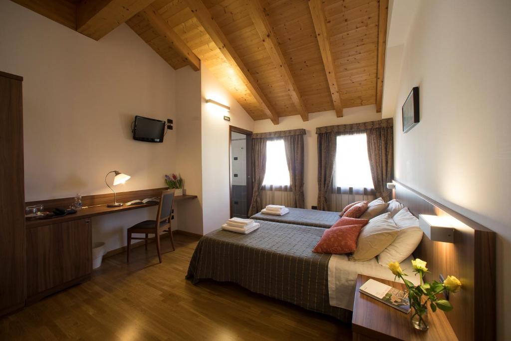 Habitación de hotel con cama, escritorio y escritorio. en Hotel C25, en Ponzano Veneto