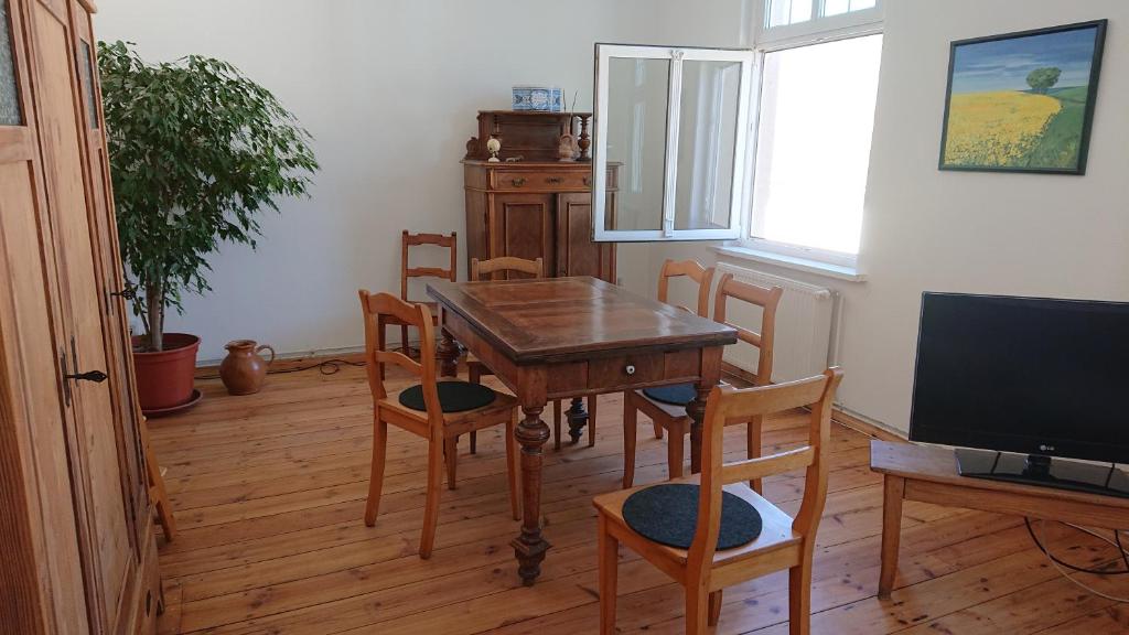 a dining room with a table and chairs and a television at Fewo in Neustadt/Dosse, der Stadt der Pferde in Leddin
