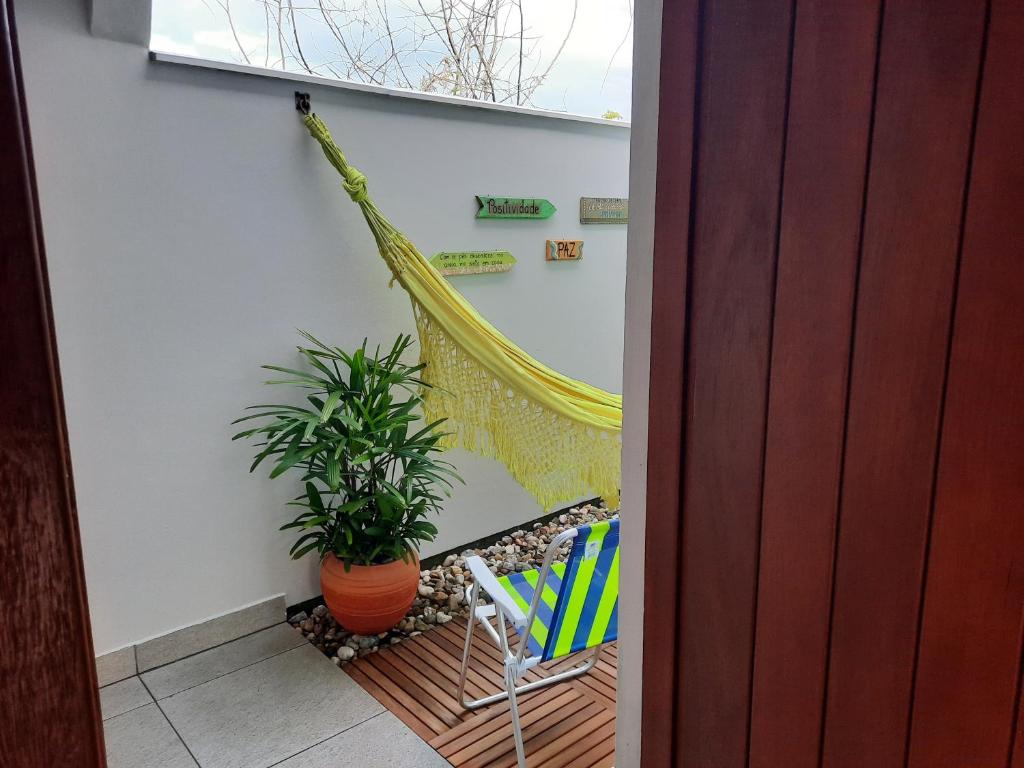 een balkon met een hangmat, een stoel en een plant bij Recanto dos Guimarães in Palhoça