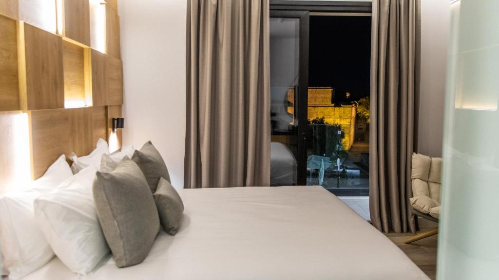 a bedroom with a bed with white sheets and pillows at Old Port Hotel in Limassol