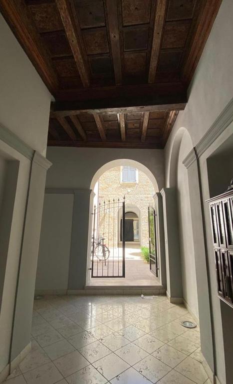 un corridoio vuoto con porta aperta su un cortile di Casa Celin:in centro storico ad un passo dal mare a Pesaro