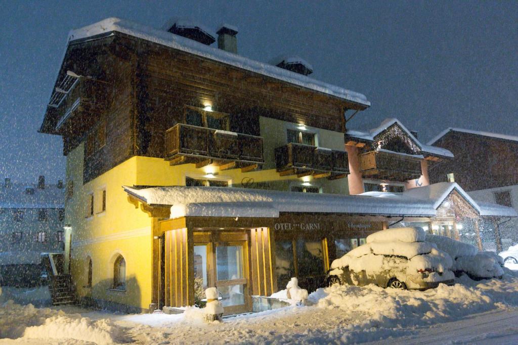 un gran edificio con nieve delante en Hotel Champagne, en Livigno