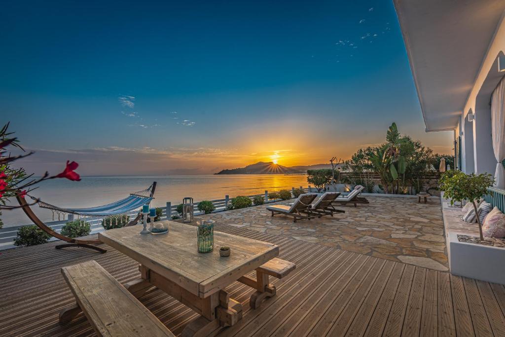 eine Terrasse mit einem Tisch und Meerblick in der Unterkunft Anemos Beach House in Alikanas