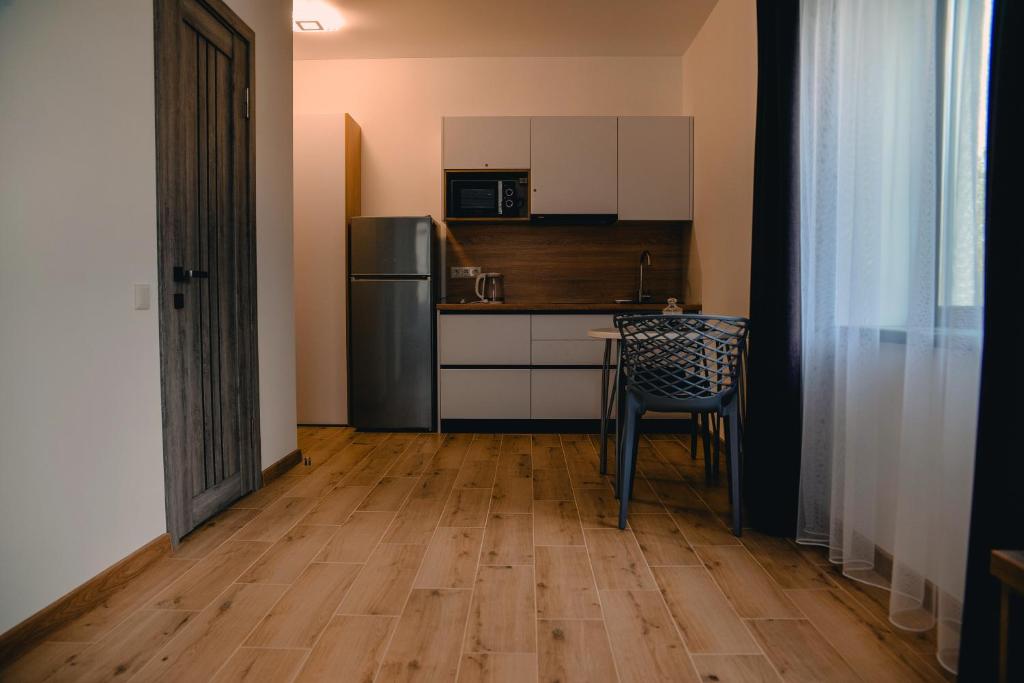 een keuken met een koelkast, een tafel en een stoel bij Four Rooms Apartments in Tsjerkasi