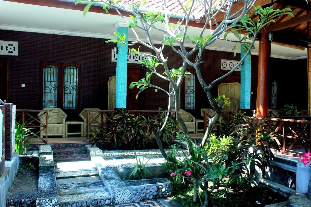 a garden with a cross in front of a building at Krisna Bungalows and Restaurant in Sekotong