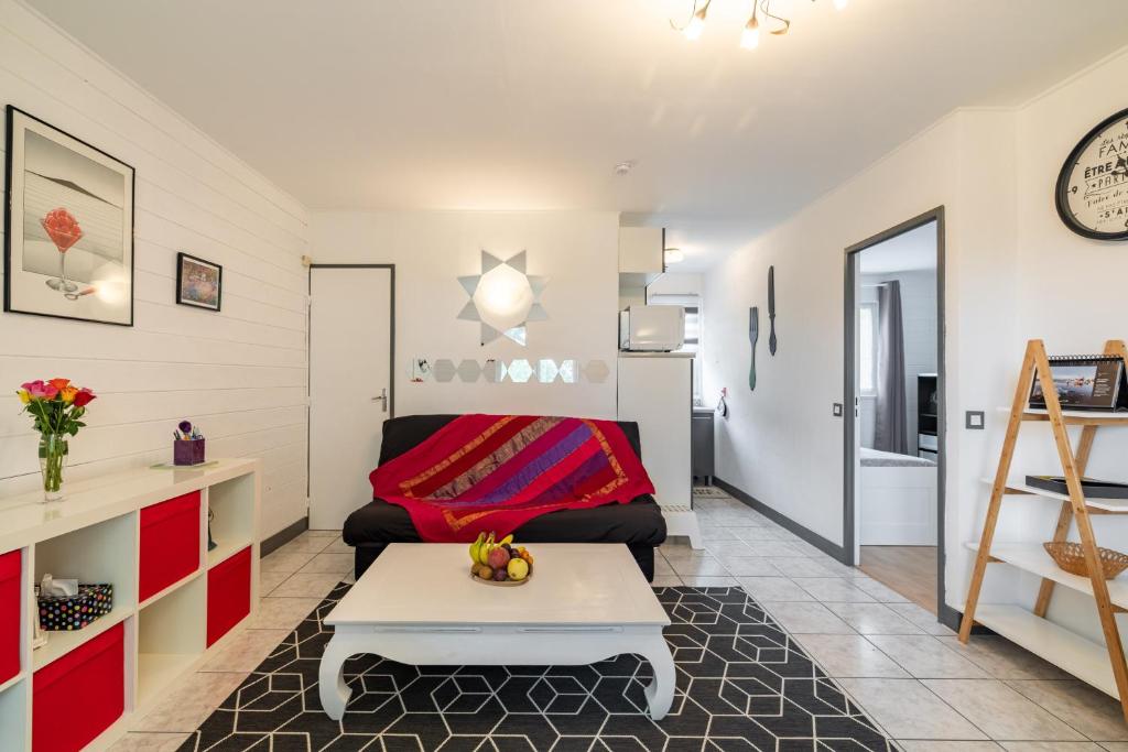 a living room with a couch and a table at Le Saphir in Branville