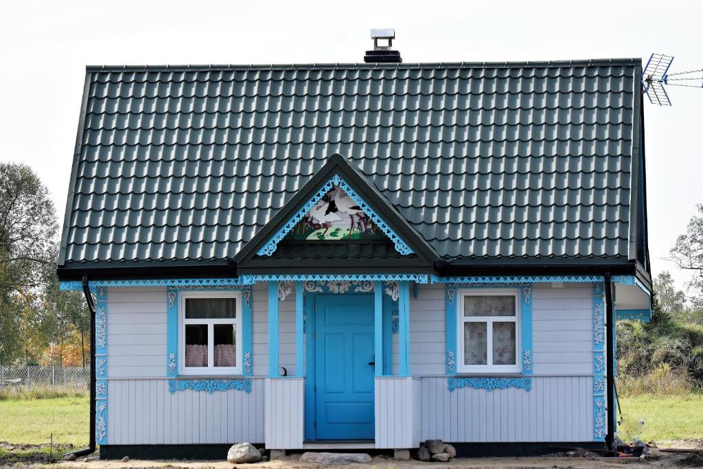 uma casa azul e branca com um telhado preto em Dom na Starym Gościńcu Tiszyna em Dubicze Cerkiewne