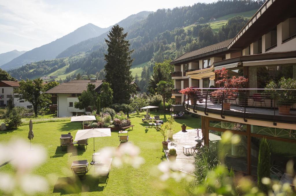 ein Resort mit einer Liegewiese mit Tischen und Stühlen in der Unterkunft Hotel Theresia in St. Leonhard in Passeier