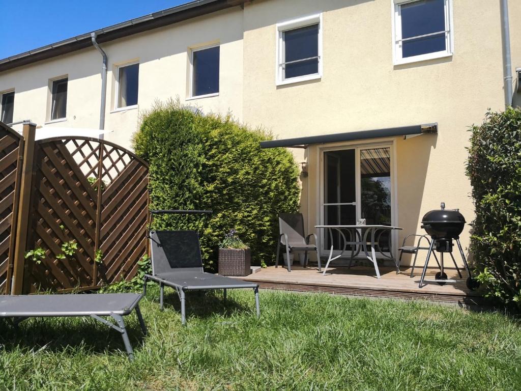 eine Terrasse mit Stühlen und einem Grill vor einem Haus in der Unterkunft Zur Schwedenschanze 2 in Hohen Wieschendorf