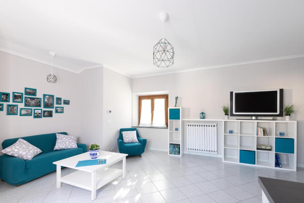 sala de estar con sofá azul y TV en Tuscany To Love - Holiday Home - Casa Vacanze, en Pieve a Nievole